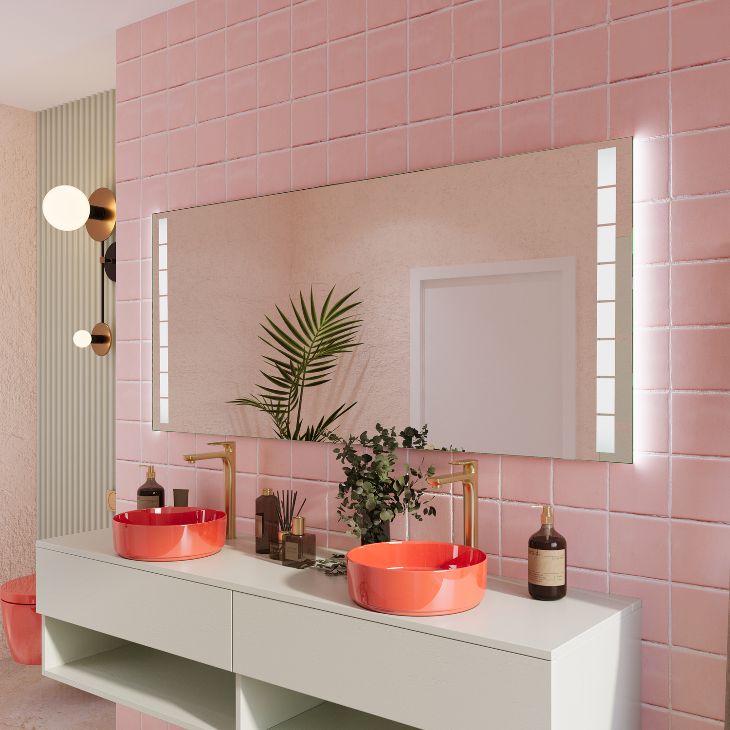 Formentera Wandspiegel mit vertikalen LED-Lichtstreifen in seitlicher Ansicht, rotes rundes Aufsatzwaschbecken auf weißem Waschtisch mit offenen Fächern, rosafarbene Fliesenwand, Kupfer-Wandleuchte, Zimmerpflanzen, moderne Badezimmereinrichtung