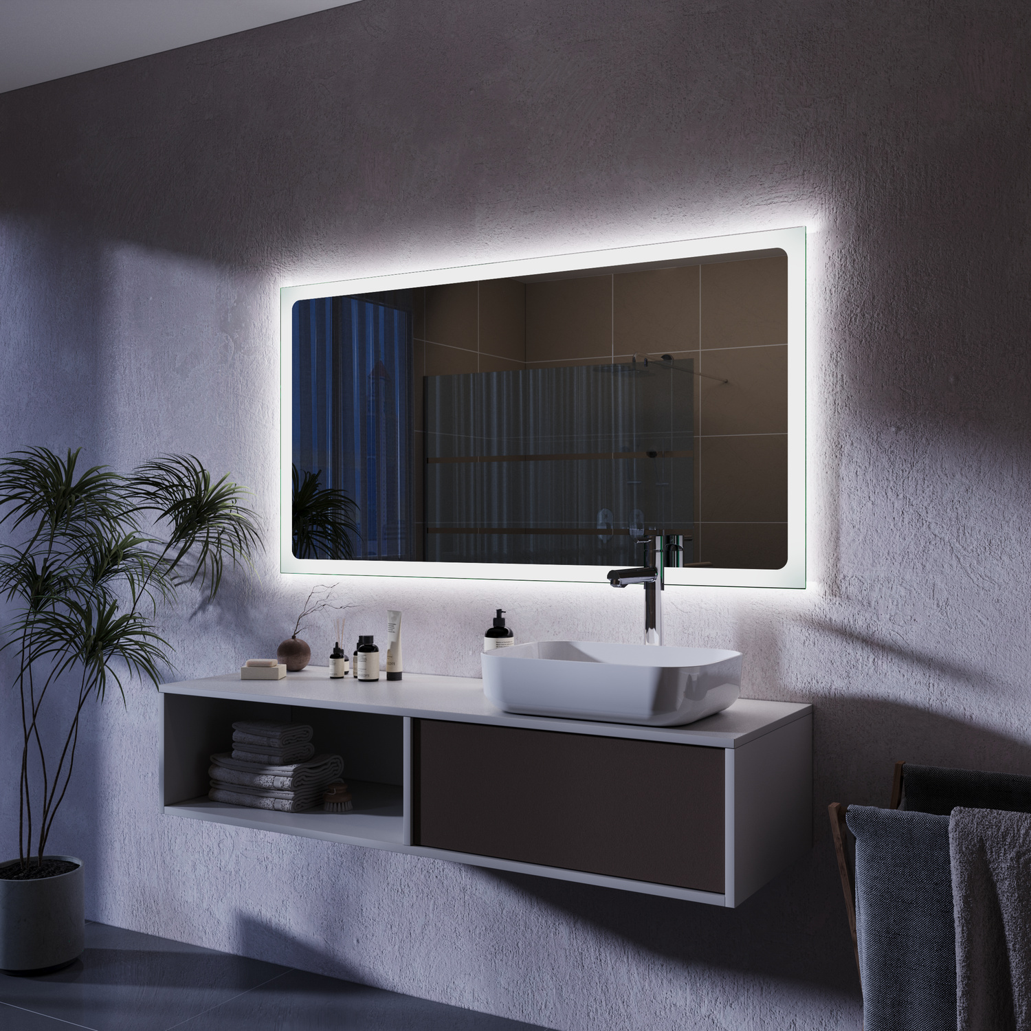 TRAPANI LED-Badspiegel seitliche Ansicht mit breitem hellem Rahmen, 1500x1500 mm, eingeschaltete warmweiße Hintergrundbeleuchtung leuchtend, nächtliche Atmosphäre, über modernem schwebendem Waschtisch mit dunklen Fronten, Grünpflanzen, dunkelgraue Betonwä