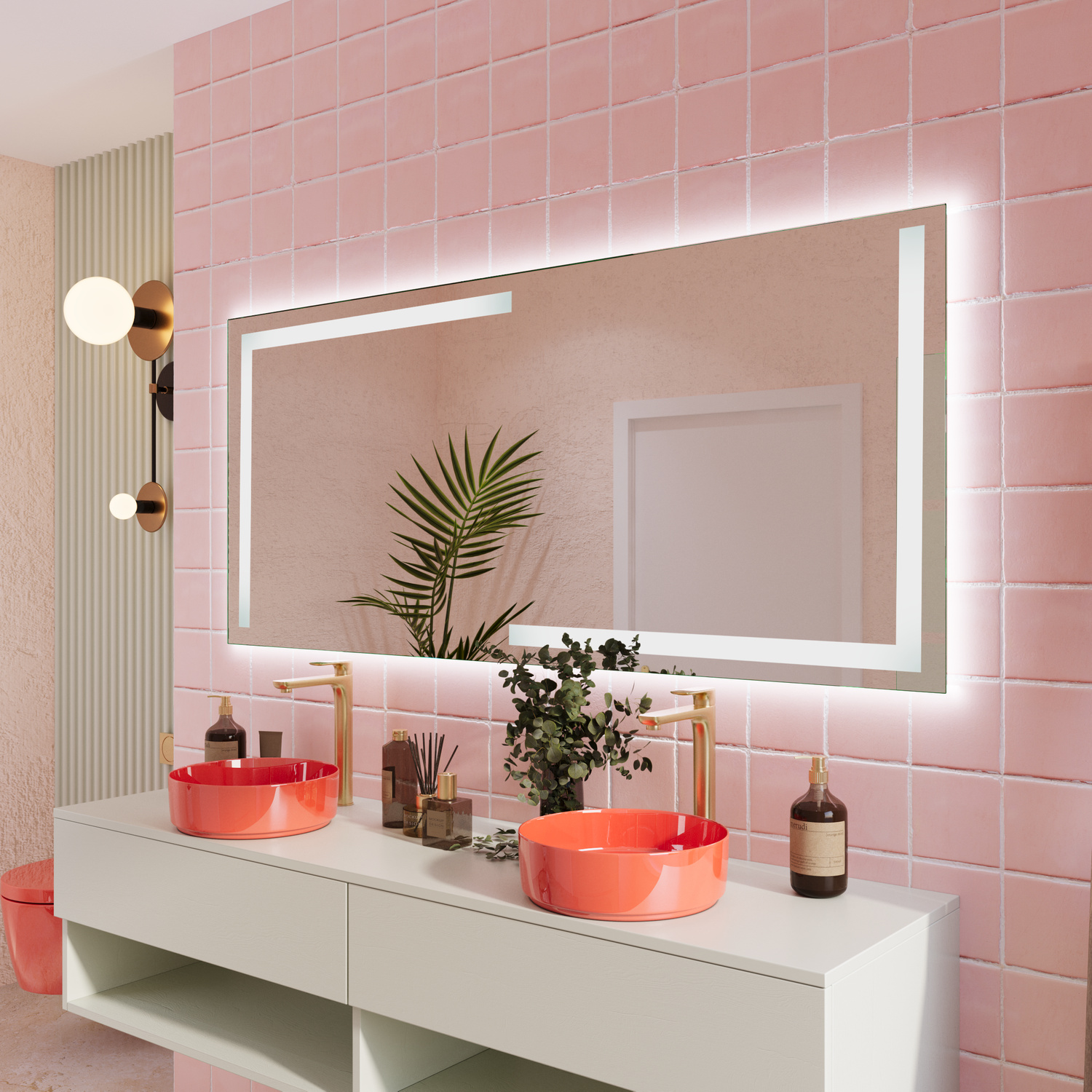 COSENZA LED-Badspiegel mit eingeschalteter Beleuchtung, 1500x1500 mm, warmweißes Licht im silbernen Rahmen, Seitenansicht über weißem Waschtisch mit rotem rundem Aufsatzwaschbecken, modernes Bad mit rosa Fliesenwand, goldener Wandleuchte