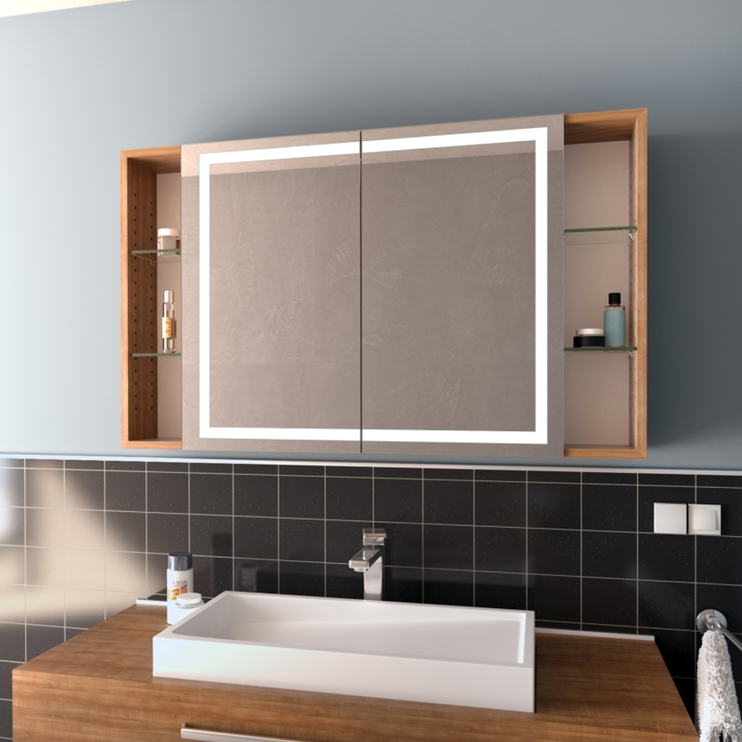 Spiegelschrank Modell Lund aus seitlichem Blickwinkel mit eingeschalteter LED-Beleuchtung, Holzrahmen und offenen Seitenfächern über modernem Waschbecken.