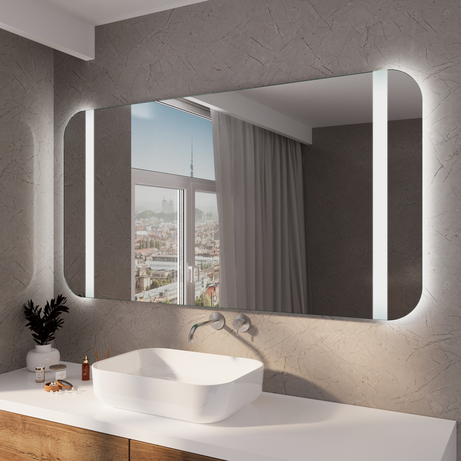 PALEE RAD LED-Badspiegel eingeschaltet, 1500x1500 mm, rechteckiger Spiegel mit abgerundeten Ecken und warmweißer seitlicher LED-Beleuchtung an dunkelgrauer Wand, weißes rundes Aufsatzwaschbecken, weiße Platte, goldene Armatur, Fenster mit Vorhang, Pflanze