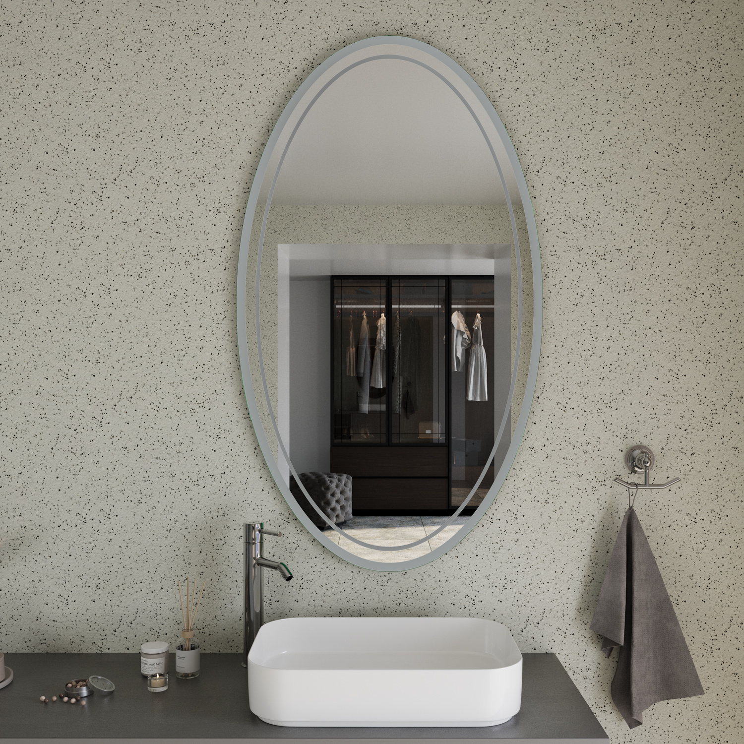 AMADORA EL Badspiegel ausgeschaltet, 1500x1500 mm, Nahaufnahme mit ovalem Spiegel in silbernem Rahmen an hellgrauer gesprenkelter Wand, weißes rechteckiges Aufsatzwaschbecken auf schwarzer Platte, schwarze hohe Armatur, Kleiderschrank spiegelt sich, graue