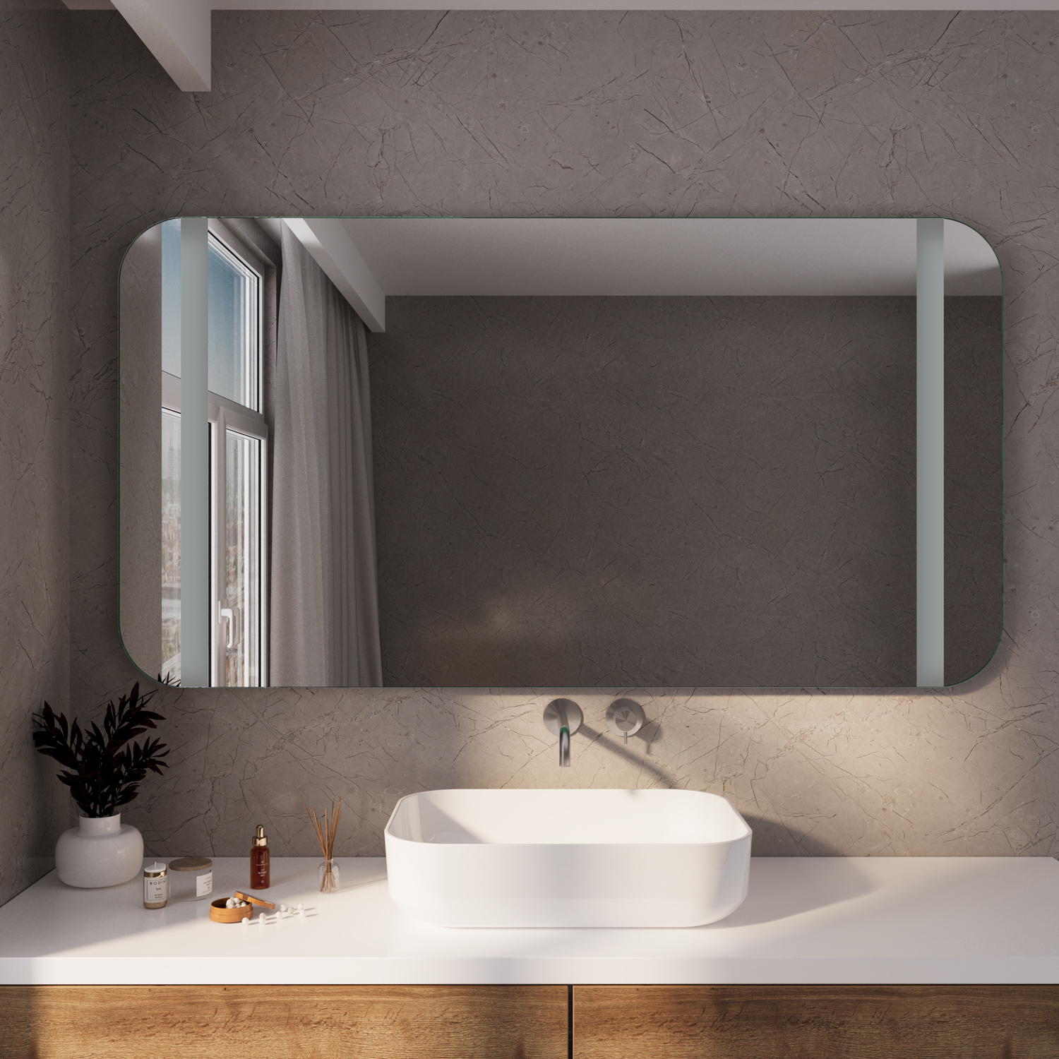 PALEE RAD Badspiegel ausgeschaltet, 1500x1500 mm, Frontansicht mit rechteckigem Spiegel mit abgerundeten Ecken in silbernem Rahmen an dunkelgrauer Wand, weißes ovales Aufsatzwaschbecken, weiße Platte, goldene Armatur, Fenster, Pflanze, Kerze, modernes ele