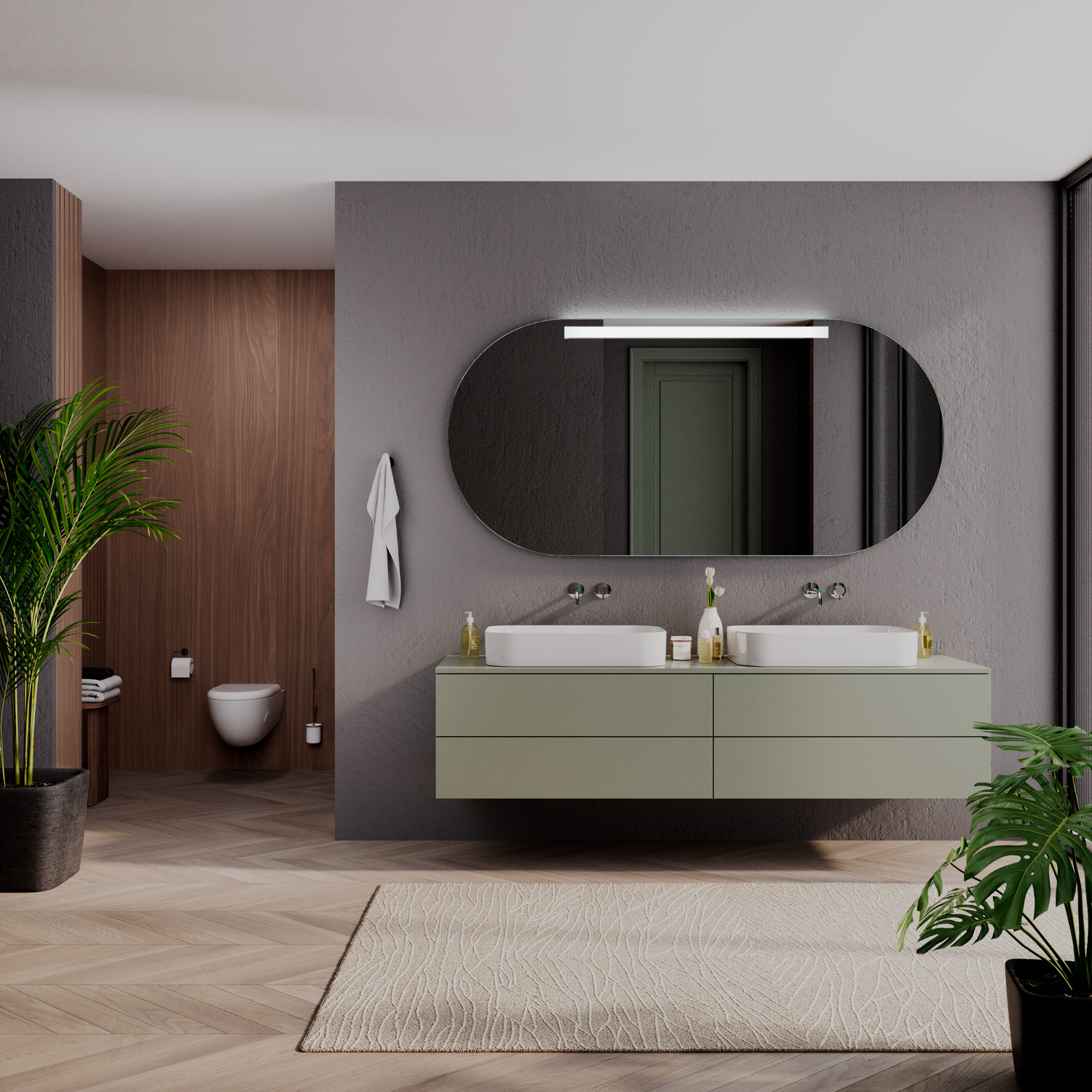 LYON OV LED-Badspiegel eingeschaltet, 1500x1500 mm, ovaler Spiegel mit warmweißer oberer LED-Beleuchtung an dunkelgrauer Wand über schwebendem olivgrünen Doppelwaschtisch, zwei weiße rechteckige Aufsatzwaschbecken, goldene Armaturen, beiger Teppich, Holzb