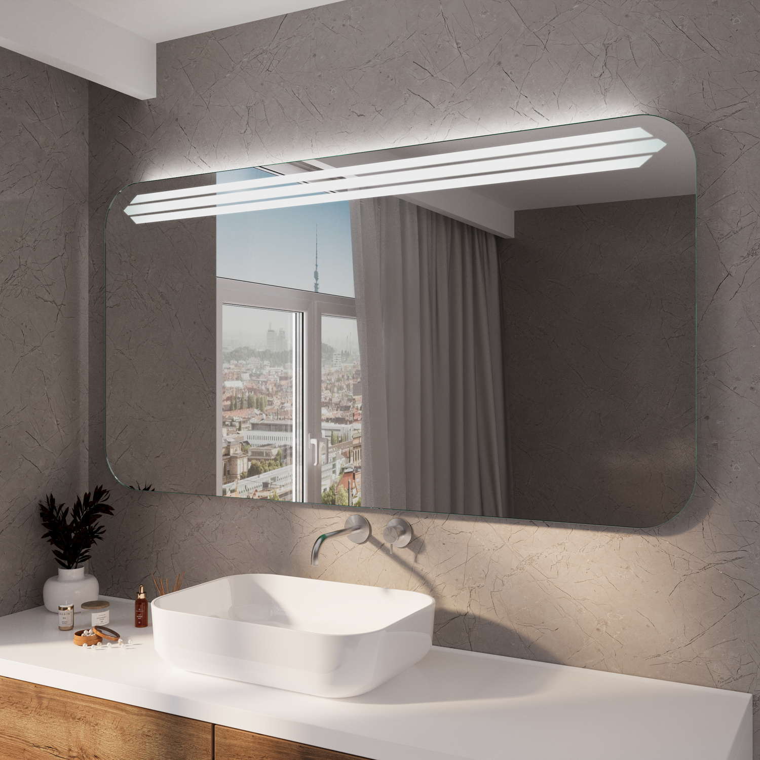 KUMASIS RAD rechteckiger LED-Badspiegel mit eingeschalteter Beleuchtung, 1500x1500 mm, leuchtend mit warmweißem Lichtstreifen oben, abgerundete Ecken, zentral über weißem Aufsatzwaschbecken, modernes Bad mit grauer Wand, Dekopflanze und Fenster mit Stadtb